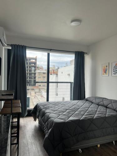 a bedroom with a bed and a large window at Apart Hotel CABA in Buenos Aires