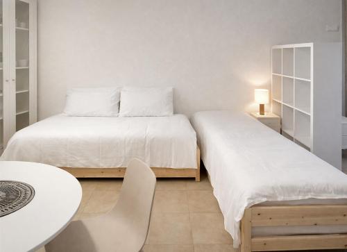 a bedroom with two beds and a table and a table at Dolomiti Relax Home in Perarolo di Cadore