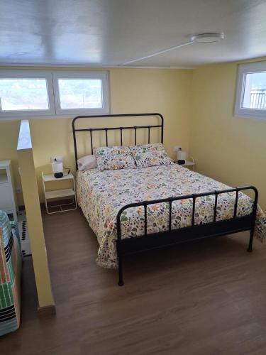 a bedroom with a bed and two windows at Mar de Pantin in Valdoviño