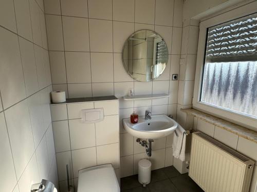 a bathroom with a sink and a toilet and a mirror at Hotel Hohe Wart in Herbrechtingen