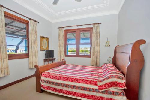 a bedroom with a bed with a colorful blanket on it at The Lakes Cottage in Tea Gardens