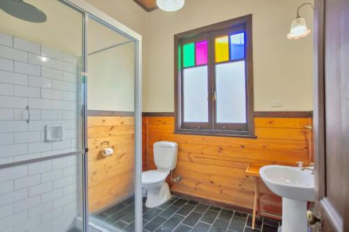 a bathroom with a toilet and a sink and a window at The Lakes Cottage in Tea Gardens