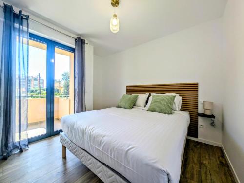 a bedroom with a large bed and a large window at La Régalide 2 B in Roquebrune-Cap-Martin