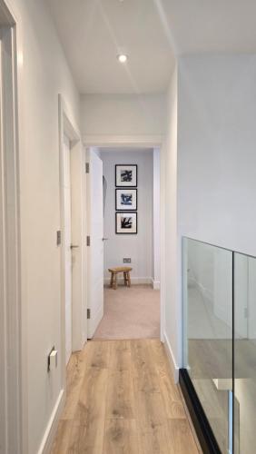 a hallway with white walls and a wooden floor at Modern 2 Bedroom with Parking in Central Windsor next to Castle & Shops in Windsor