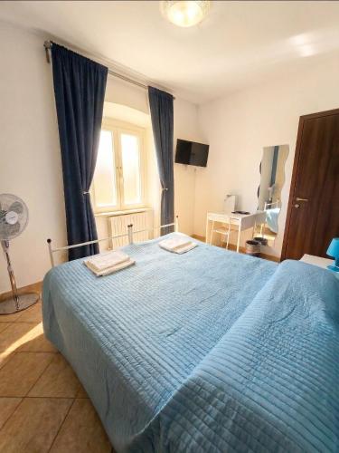a bedroom with a blue bed and a window at La Piazza B&B in Vercurago