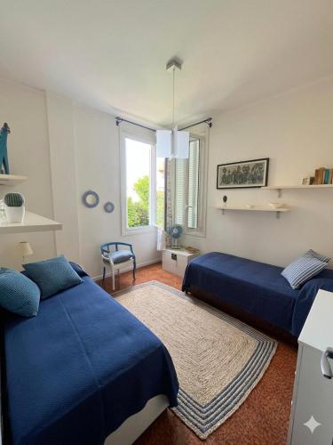 a bedroom with two blue beds and a window at La casa di Giò in Varazze