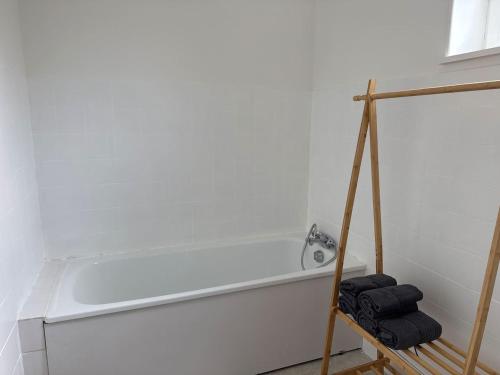 a bathroom with a bath tub with three black towels at Appartement Voltaire in Romilly-sur-Seine