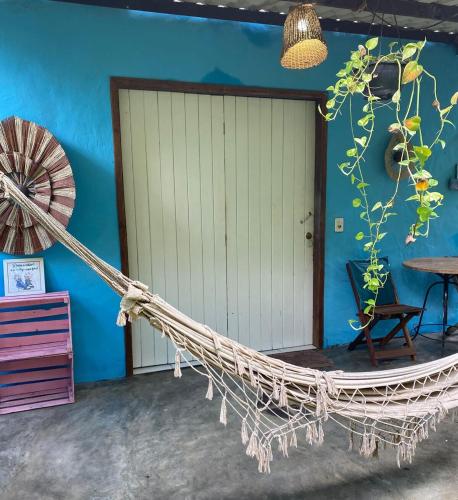 a hammock in front of a blue wall at Casa Flor in Ilha de Boipeba