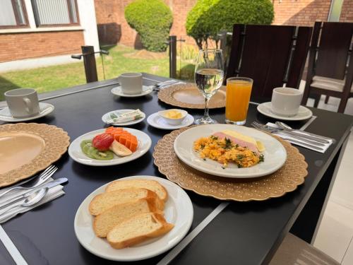 a black table topped with plates of food and toast at D'Acosta Hotel Belencito in Nobsa