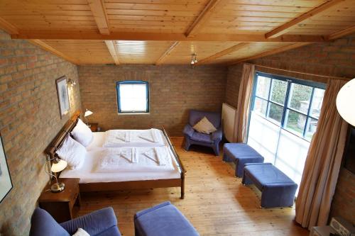 a bedroom with a bed and chairs in a room at Blankenese in Ahlbeck