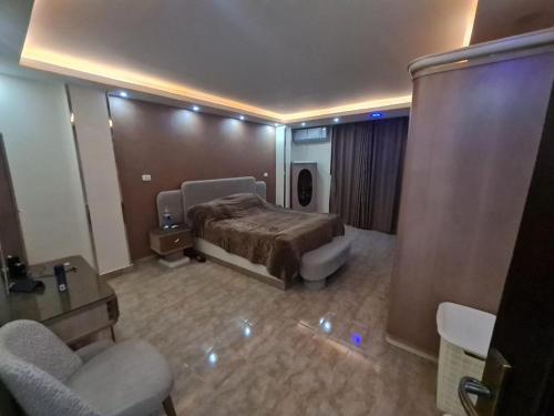 a bedroom with a bed and two chairs in a room at Fatah Apartment 13 in Luxor