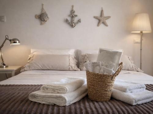 a bedroom with towels and a basket on a bed at Little Medieval House Nettuno in Nettuno