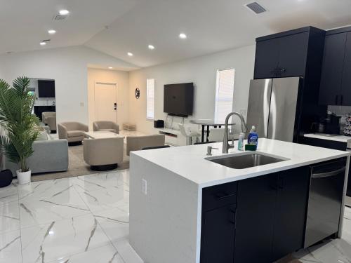 a kitchen with a sink and a living room at Palm Luxe Residence in West Palm Beach