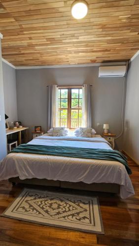 a bedroom with a large bed with a window at Hospedaria Casa Verde in Itapoa