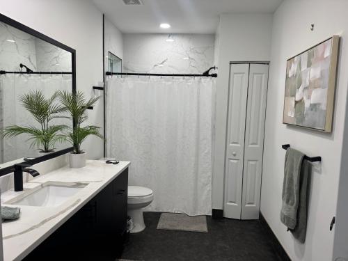 a bathroom with a sink and a toilet and a shower at Palm Luxe Residence in West Palm Beach
