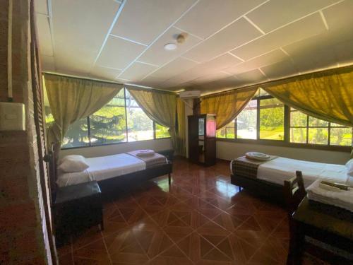 a bedroom with two beds and windows in it at Grand Selva Lodge & Tours in Tena
