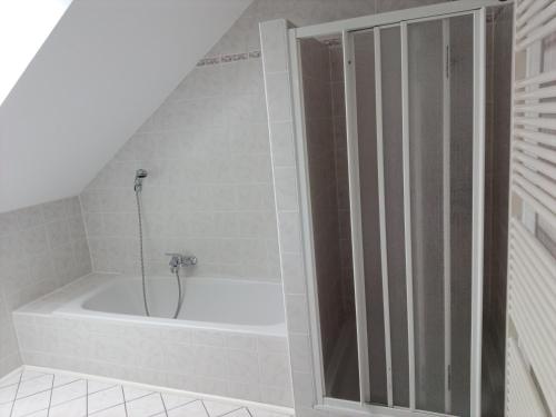 a bathroom with a bath tub with a shower at Wohnen mit Panoramablick in Gramastetten