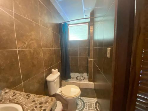 a small bathroom with a toilet and a shower at Grand Selva Lodge & Tours in Tena