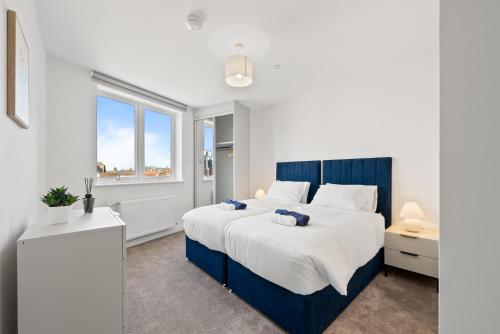a bedroom with a large bed and a window at Luxury 2BR Staines 12 Mins to Heathrow & Thames in Staines