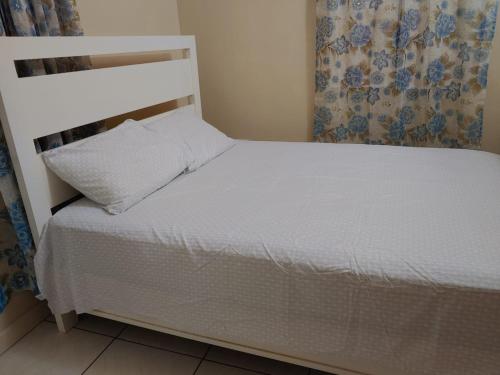 a bedroom with a white bed with a white headboard at Vincy vybz in Kingstown