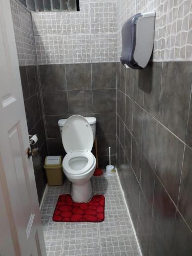 a bathroom with a toilet with a phone on the wall at Vincy vybz in Kingstown