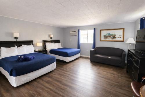 a hotel room with two beds and a couch at Sierra Inn in Prescott