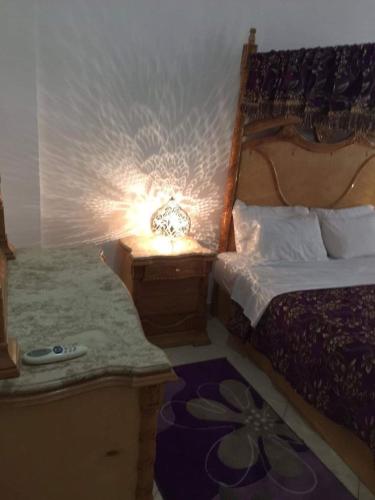 a bedroom with a bed and a lamp on a table at Fatah Apartment 14 in Luxor