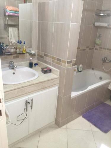 a bathroom with a sink and a bath tub at Fatah Apartment 14 in Luxor