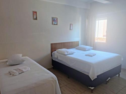 zwei Betten in einem Zimmer mit weißen Wänden in der Unterkunft Avila Hotel in Boa Esperança
