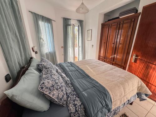 a bedroom with a bed with pillows on it at Olive Grove House in Kámpos