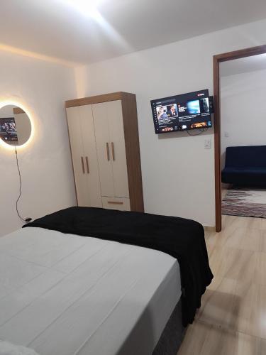 a bedroom with a bed and a flat screen tv at Microcasa com ar em Resende in Resende