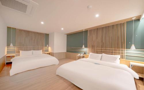 a bedroom with two beds and a window at 스테이 공담호텔 in Kyū-masan