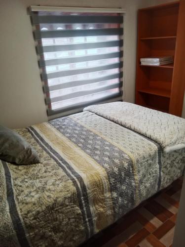 a bedroom with a bed and a window with a blind at Refugio Rancagua in Pueblo de Naturales