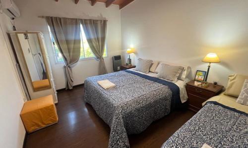 a hotel room with two beds and a mirror at Duplex Jauregui en Lujan in Luján