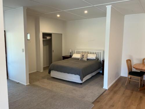 a bedroom with a bed and a table and a desk at River and Mountain Central in Queensberry