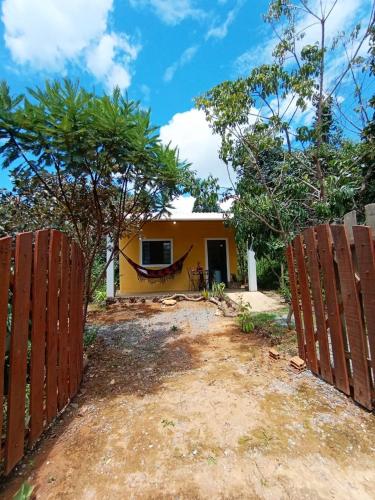 a house with a fence in front of it at Chalé dos Lírios in Alto Paraíso de Goiás