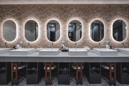a bathroom with four sinks and four mirrors at GOYOO INN & cabins in Seoul