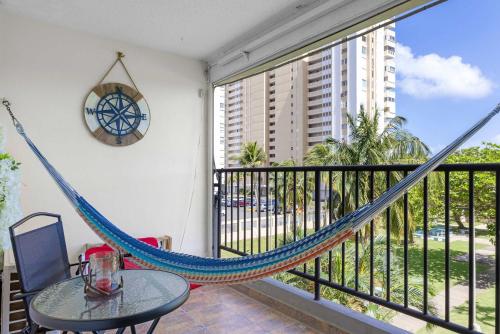 a hammock on a balcony with a table and a clock at Playa Azul Beach by Otium in Luquillo