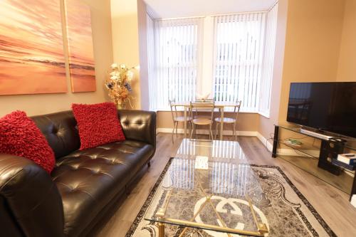 a living room with a leather couch and a table at Modern 1 Bedroom Apartment Free Parking WiFi Near City Centre in Leeds
