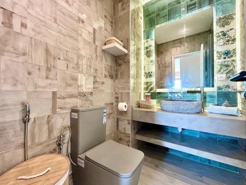 a bathroom with a toilet and a sink and a mirror at 360 Oceanfront & Sunset View Condo - Terrace & 2BR in Tangier