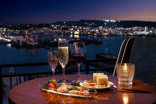 a table with two glasses of wine and a plate of food at Southern Beach Hotel & Resort Okinawa in Itoman