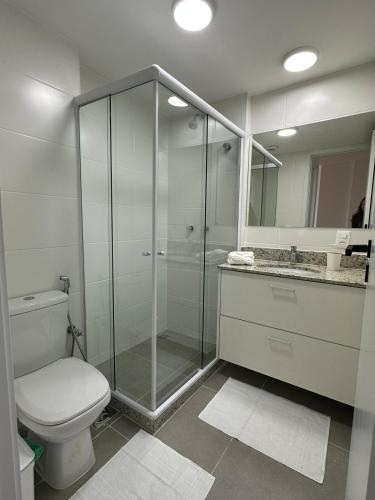 a bathroom with a toilet and a glass shower at Piratininga a Beira Mar - Niterói in Niterói