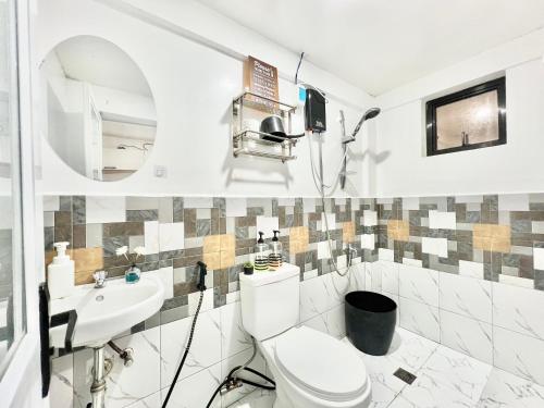 a bathroom with a toilet and a sink at 2 Beds Spacious Centrally Located Loft Apartment in Naga