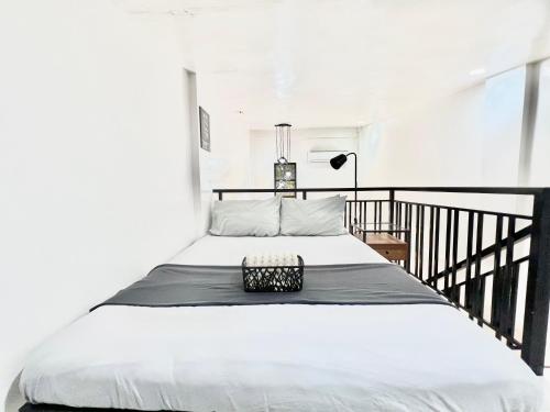 a bedroom with a bed with a black railing at 2 Beds Spacious Centrally Located Loft Apartment in Naga