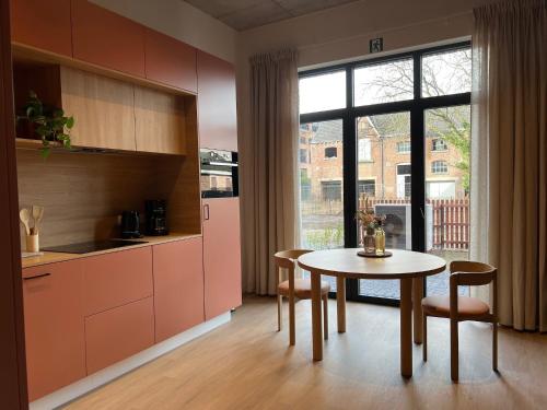 a kitchen with a table and chairs and a window at Charming ground-floor apartment in Bree in Bree