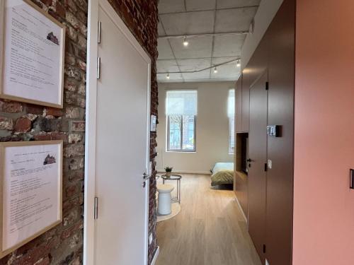a room with a brick wall and a hallway at Charming ground-floor apartment in Bree in Bree