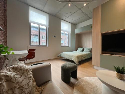 a bedroom with a bed and a desk and a tv at Attractive apartment in Bree for 2 guests in Bree