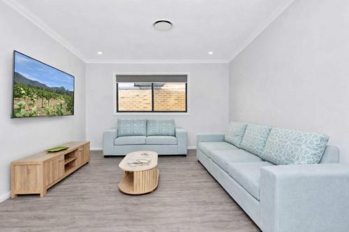 a living room with a couch and a coffee table at Huntlee Heights in North Rothbury