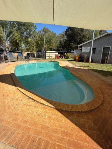 a large swimming pool with an umbrella in a yard at Waters Edge Retreat in Dawesville