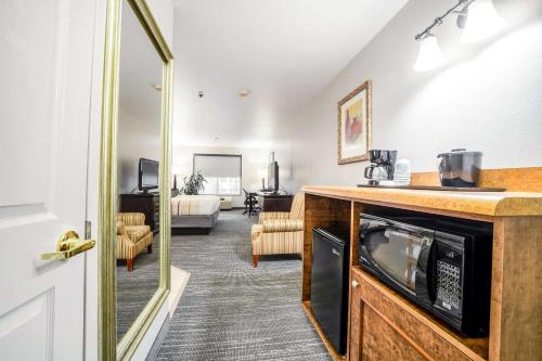 a room with a kitchen with a microwave and a living room at Country Inn & Suites by Radisson, Ontario at Ontario Mills, CA in Ontario